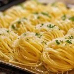Pâtes au beurre et à l’ail dans une assiette blanche