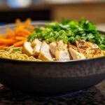 Bol de ramen au poulet crémeux à l’ail avec garnitures fraîches