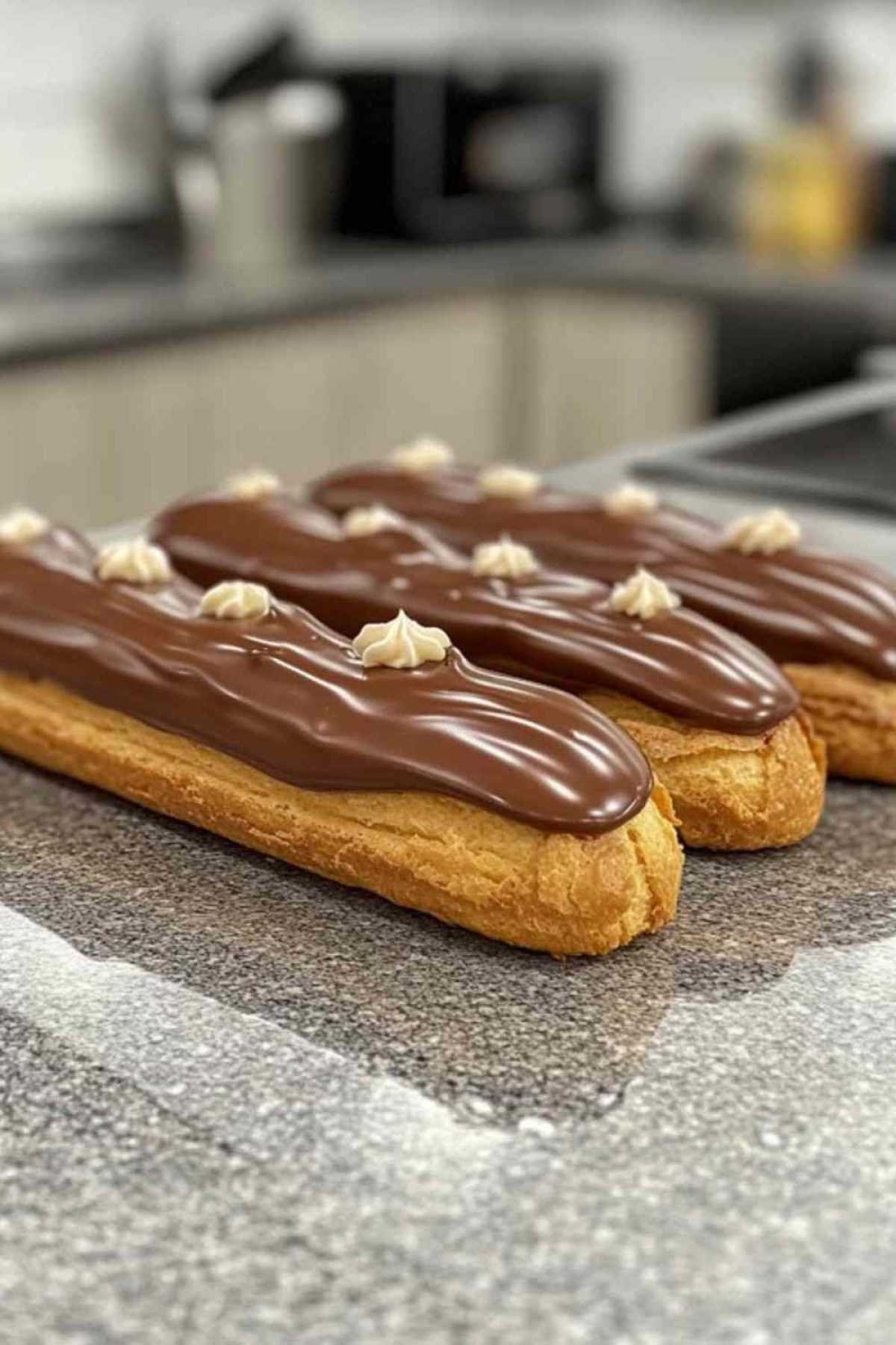 Garnissage d’éclairs au chocolat avec de la crème pâtissière